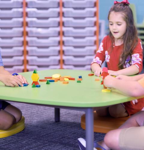 Children building blocks at a low table