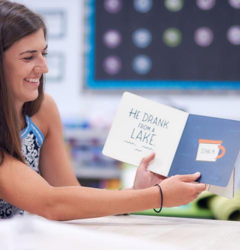 A teacher reading a book to elementary students.