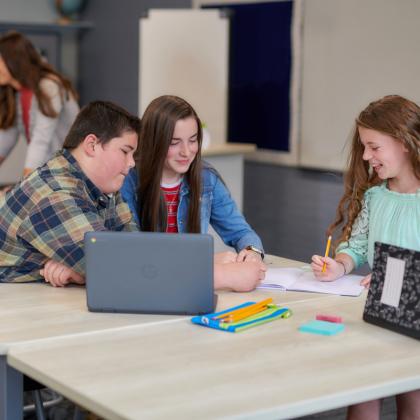 Three middle school students working on an assignment together.