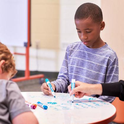 Young boy drawing at table.
