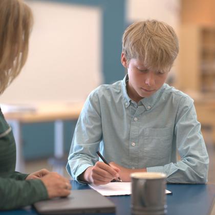 Teacher helping student with assignment.