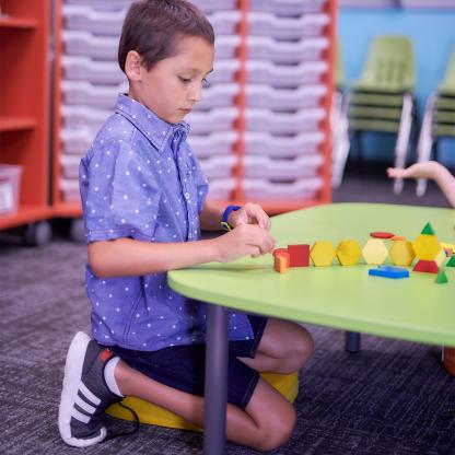Young boy playing with blocks at a short table