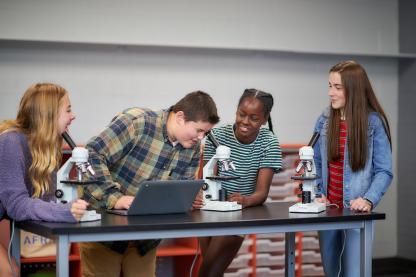 Students using laptops and microscopes