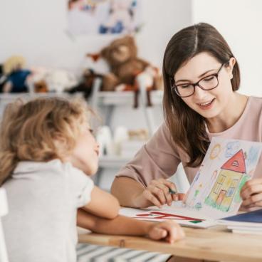 A woman reading a book to a young girl.