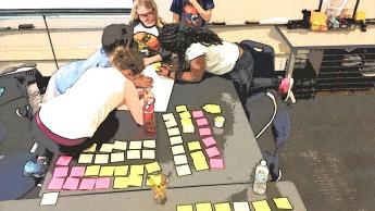 Students leaning over a table as they work together
