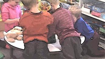 Young children gathered around a table.